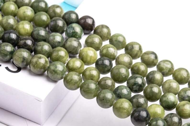 Pu&ograve; includere: Una collana di perle di giada verde. Le perle sono rotonde e hanno una finitura liscia e lucida. Sono infilate su un filo trasparente.