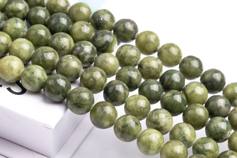 Pu&ograve; includere: Una collana di perle di giada verde e bianca. Le perle sono rotonde e lisce, e hanno un aspetto naturale e organico.