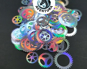 May include: A large pile of iridescent holographic gear shapes, with a small sticker that says "Reino Aventura" in the center.