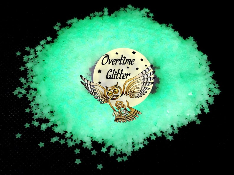 May include: A pile of light green star-shaped glitter on a black background. The glitter surrounds a circular logo with an owl illustration and the words "Overtime Glitter". The owl is brown and gold.