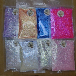 May include: Assortment of ten small bags of iridescent glitter in various colors, including purple, pink, blue, white, and peach. Each bag has a label that reads "Creative Glitter".