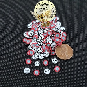 May include: A collection of polymer clay Jack Skellington face and emblem slices in red, white, black, and blue. The image includes a penny for size reference and a gold owl logo with the text "Overtime Glitter".