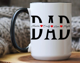 Może przedstawiać: Biały kubek ceramiczny z czarnym uchwytem i czarnym napisem "DAD" z nazwami "Kristin", "Emily", "Liam" i "Kayla" napisanymi pod literami z czerwonymi sercami między każdym imieniem.