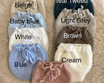 May include: Ten knitted baby bloomers in various colors, including beige, baby blue, white, blue, blush, teal tweed, light grey, brown, and cream.