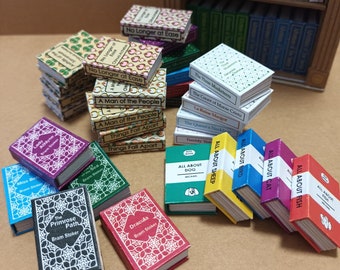 May include: Miniature books with various titles and colors, including "Dracula" and "All About Dog." The books are arranged in stacks and rows, with a wooden bookshelf in the background. The books are likely for a dollhouse or miniature collection.