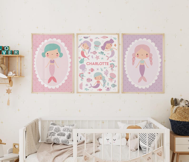 May include: Three pink and purple framed prints with illustrations of mermaids and the name Charlotte. The prints have a scalloped border and a white background.