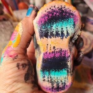 May include: A colourful, hand-painted ceramic sculpture with a textured surface. The sculpture is painted in shades of pink, blue, green, yellow, and black.