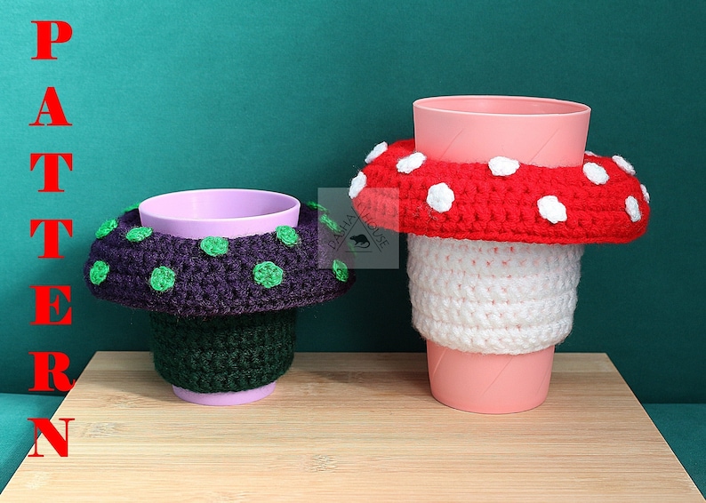May include: Two crochet cup cozies shaped like mushrooms. The left cozy is dark purple with green spots on a dark green base. The right cozy is red with white spots on a white base. The word PATTERN is written vertically in red on the left.