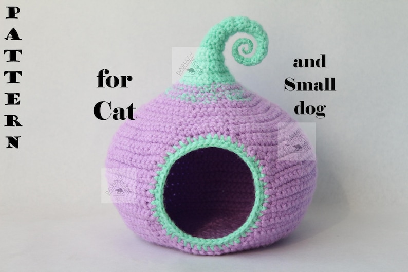 May include: A handmade crochet pet bed in a bulbous shape, primarily lavender with mint green accents. The bed has a circular opening and a decorative swirl at the top. Text on the image reads "PATTERN for Cat and Small dog."