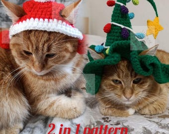 May include: Two ginger cats wearing crocheted holiday hats. One cat wears a red and white Santa hat with a white pom-pom. The other cat wears a green Christmas tree hat with colorful lights and a yellow star. The text "2 in 1 pattern" is visible.
