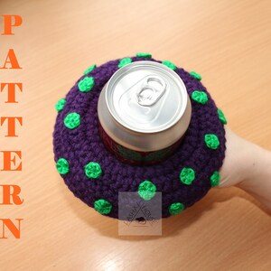 May include: A purple crocheted drink cosy with small green polka dots surrounding a silver aluminium beverage can. The word PATTERN is printed in orange vertically on the left side, and a logo with the text LASHA HOUSE is visible.