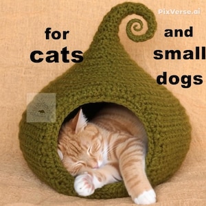 May include: A green, crocheted pet bed shaped like a pod, with a curled top. The text "for cats and small dogs" is visible. An orange tabby cat is curled up inside the bed, sleeping peacefully.