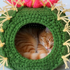 K&ouml;nnte beinhalten: Ein gr&uuml;nes, geh&auml;keltes Katzenbett in Form eines Kaktus, mit einer schlafenden, orangefarbenen Katze darin. Das Bett hat gelbe Akzente und eine rosa-gelbe Bl&uuml;te. Die Katze ist zusammengerollt und scheint friedlich zu schlafen. Ein gem&uuml;tliches Katzenzubeh&ouml;r.