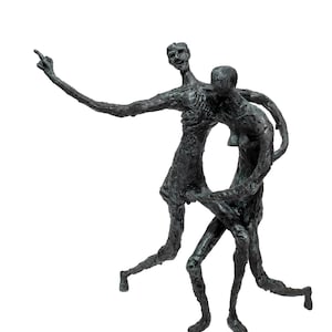 Può includere: Una scultura in bronzo raffigurante due figure in una posa dinamica. Una figura indica verso l'alto con un braccio teso, mentre l'altra è abbracciata. La scultura ha una superficie strutturata e una patina scura e invecchiata.