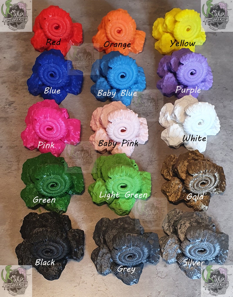 May include: A collection of 12 ammonite-shaped resin rocks in various colors, including red, orange, yellow, blue, baby blue, purple, pink, baby pink, white, green, light green, gold, black, grey, and silver.