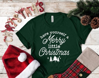 May include: Green t-shirt with white text that reads "have yourself a Merry little Christmas". The text is in a festive font with a small Christmas tree graphic below it.