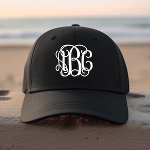 May include: Black baseball cap with a white monogram of the letters "ABC" in a script font.
