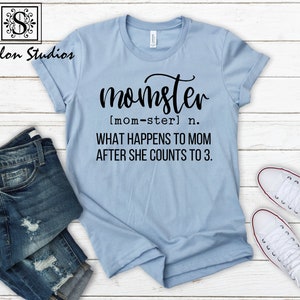May include: A light blue t-shirt with black text that reads "momster [mom-ster] n. WHAT HAPPENS TO MOM AFTER SHE COUNTS TO 3."