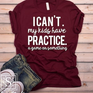 May include: A maroon t-shirt with white text that reads "I CAN'T. my kids have PRACTICE. a game or something."