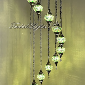 Op de afbeelding: Een spiraalvormige kroonluchter met 8 groene glazen bollen, elk met een mozaïekpatroon. De kroonluchter is 86 inch hoog en 25 inch breed. Elke bol is 5 inch breed en 4 inch hoog. H11-25
