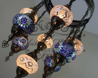 May include: A chandelier with eight mosaic glass globes. The globes are in shades of blue and white. The chandelier is made of metal and has a circular frame.