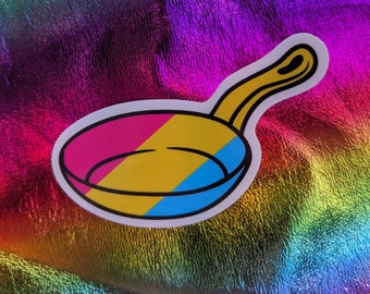 May include: A sticker of a frying pan with a blue, yellow, and pink design. The pan is white with a black outline.