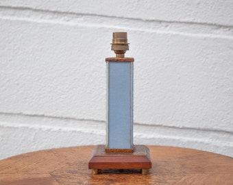 May include: A blue and wood table lamp with a brass lampshade. The lamp has a square base and a rectangular shade.