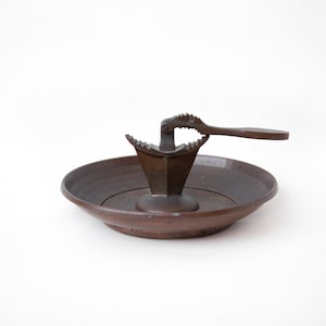 Peut inclure: Un casse-noisette en cuivre vintage avec une poignée et un petit bol pour recueillir les coquilles de noix.