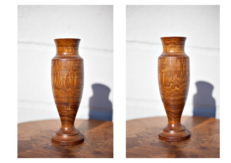 Peut inclure: Un vase en bois avec une finition en bois naturel brun. Le vase a un corps arrondi et une base &eacute;vas&eacute;e.