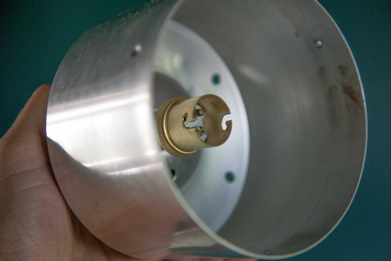 K&ouml;nnte beinhalten: Eine silberne Metall-Lampenfassung mit einer Messing-Gl&uuml;hbirnenfassung.