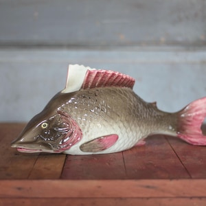 May include: A set of three ceramic mugs with a speckled, matte finish. The mugs are in shades of cream, light gray, and dark gray. Each mug has a simple, minimalist design, perfect for coffee or tea.