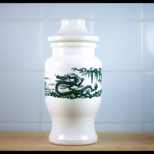 Peut inclure: Pot en céramique blanche avec un motif de dragon vert et blanc. Le pot a un couvercle et est décoré d'un dragon vert et de motifs floraux.