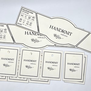 May include: A set of white hang tags with black trim and text that reads "HANDKNIT with love". The tags are designed for handmade knit items and include care instructions.