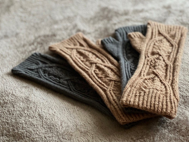 May include: Three pairs of knitted arm warmers in a cable knit pattern. Two pairs are brown and one pair is gray.