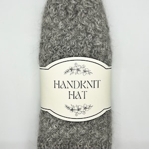 May include: A grey hand-knitted hat with a white label that says "Handknit Hat".