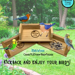 May include: Cedar bird feeder with three platforms. The feeder is made of natural wood and has a brown stain. The feeder is decorated with the words "King Wood Clocks" and "Cedar Platform Bird Feeder". There are three birds on the feeder, a bluebird, a green parakeet, and a red and orange bird. The feeder is sitting on a green lawn.