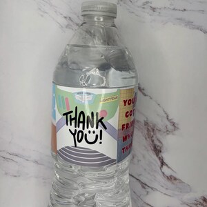 May include: A clear plastic water bottle with a custom label featuring a space ranger suit design, the text THANK YOU!, and the phrase YOU'VE GOT A FRIEND IN ME. The label includes green, purple, and red accents with a white background.