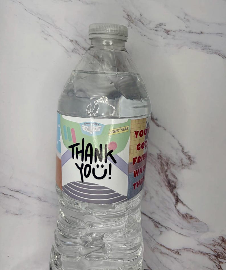 May include: A clear plastic water bottle with a custom label featuring a space ranger suit design, the text THANK YOU!, and the phrase YOU'VE GOT A FRIEND IN ME. The label includes green, purple, and red accents with a white background.
