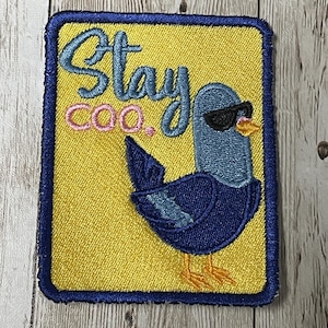 May include: Yellow embroidered patch with a blue bird wearing sunglasses and the text "Stay Coo."