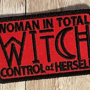 May include: Red embroidered patch with black stitching. The patch reads "Woman in Total Witch Control of Herself".