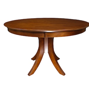 May include: A round wooden dining table with a pedestal base and three legs. The table top is a rich brown color and the base is a slightly lighter brown.