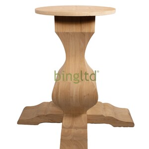 Puede incluir: Una base de mesa de madera de color claro con una parte superior redonda y un pedestal &uacute;nico en forma de reloj de arena. La base tiene un dise&ntilde;o de cuatro patas y est&aacute; hecha de madera sin terminar. La base de la mesa es adecuada para una mesa de comedor o una pieza de mobiliario similar.