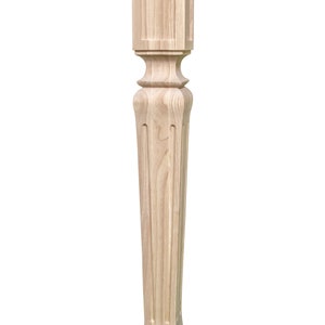 May include: A light wood table leg with a square top and a fluted, turned design. The leg is about 30 inches tall.