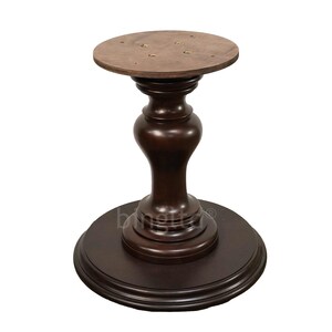 May include: A dark brown wooden table base with a round top and a pedestal base. The base has a fluted design and a smooth finish.