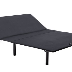 May include: A black adjustable bed frame with a fabric-covered surface. The bed frame has a head and foot section that can be raised or lowered. The frame is supported by black legs and has a metal bar at the foot of the bed.