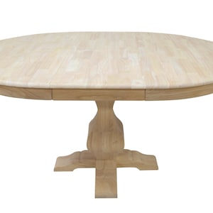 Puede incluir: Una mesa de comedor redonda de madera clara. La tapa est&aacute; hecha de tablas de madera clara. La mesa tiene una base de pedestal con una base en forma de cruz. La mesa tiene aproximadamente 122 cm de di&aacute;metro.