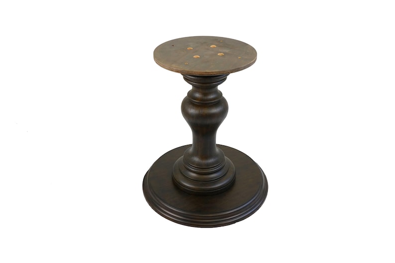 May include: A dark brown wooden table base with a round top and a pedestal base. The base has a fluted design and a smooth finish.