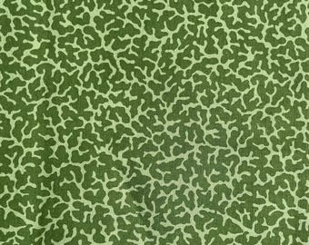 Pode incluir: Close-up de um tecido verde com um padrão repetitivo de formas orgânicas verde claro, semelhantes a corais ou estruturas ramificadas. O design cria um efeito texturizado, adequado para aplicações têxteis.