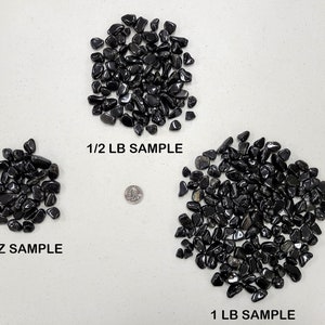 Puede incluir: Tres montones de piedras negras pulidas, etiquetados como muestra de 4 oz, muestra de 1/2 lb y muestra de 1 lb. Se muestra una moneda de 25 centavos de d&oacute;lar estadounidense para comparar el tama&ntilde;o.