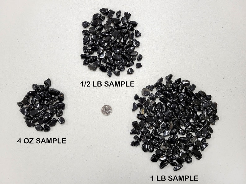 Puede incluir: Tres montones de piedras negras pulidas, etiquetados como muestra de 4 oz, muestra de 1/2 lb y muestra de 1 lb. Se muestra una moneda de 25 centavos de d&oacute;lar estadounidense para comparar el tama&ntilde;o.